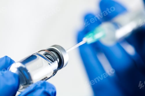 Preview: Hand in blue gloves holding syringe with needle inserted into ampoule with antiviral liquid
