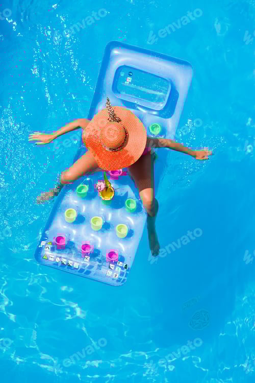 Preview: Young woman on a lilo in the swimming pool