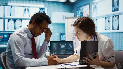 Preview: Physician comforting her male patient by holding his hand and giving her support