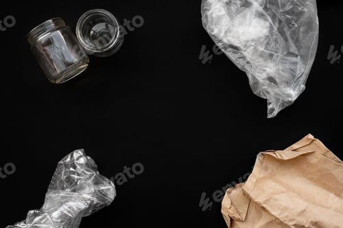 Preview: Paper, plastic and glass waste and rubbish on black background. Recycling. Copy space.