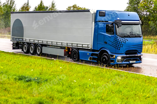Preview: Modern blue truck on wet highway. Power and reliability in motion.