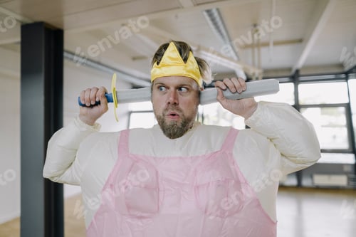 Preview: Man dressed up as a ballerina with toy sword in office