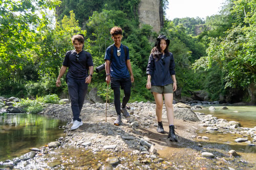 Preview: group of young asian trekking and hiking on rocky river stream