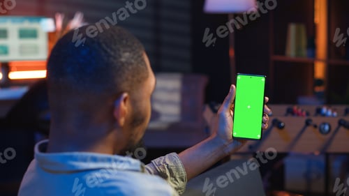 Preview: African american young adult laying on the sofa with mockup screen