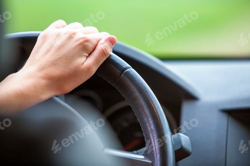 Preview: Woman hands on steering wheel driving a car