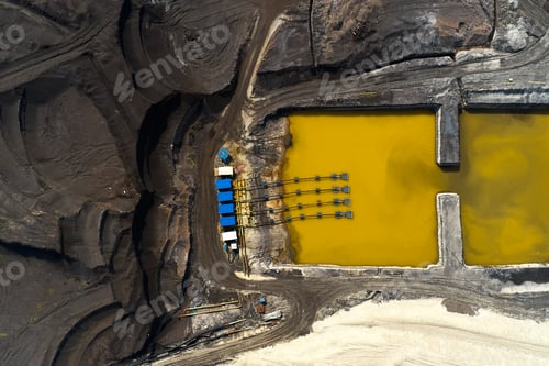 Preview: Top view on a pool with yellow liquid used in a coal mining in a quarry. Heavy industry concept