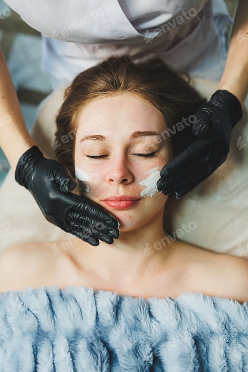 Preview: The hands of a beautician apply a mask to a woman's face in a spa salon. Aesthetic procedure