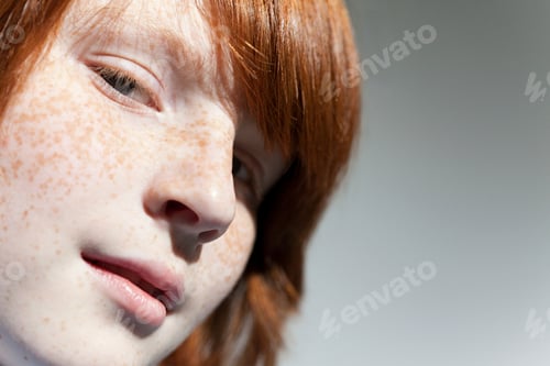 Preview: Closeup of a contemplative youth with striking freckles