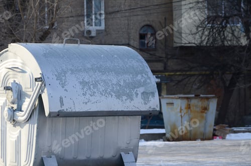 Preview: A silver garbage container stands near residential buildings in winter