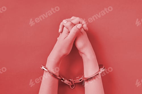 Preview: Crossed hands in handcuffs on red background