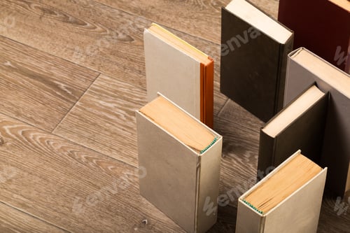 Preview: Books arranged on wooden floor creating an organized, minimalist display in a cozy environment