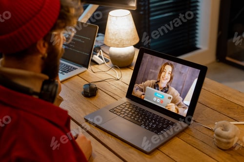 Preview: Man having online meeting with female colleague, while work at home