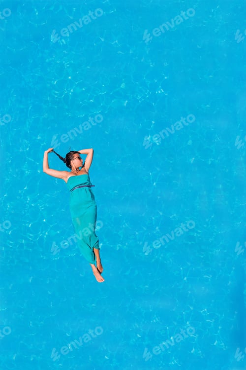 Preview: Woman floating above pool water