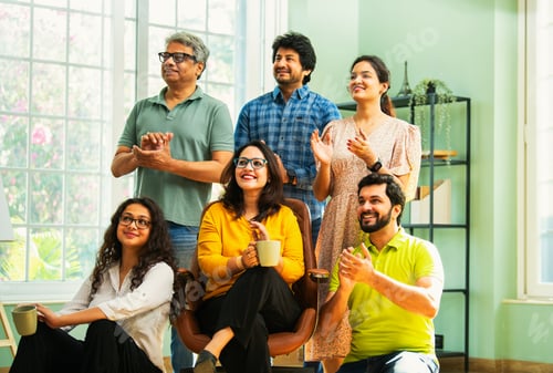 Preview: Young Indian Asian professionals in casuals clapping and looking up, celebrating success together