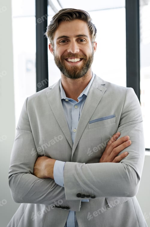 Preview: Portrait of a confident young businessman standing with his arms crossed in his office