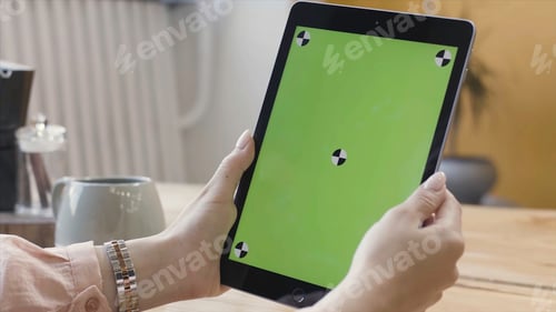 Preview: Woman tapping, scrolling and zooming on the tablet computer with green screen. Stock footage. View