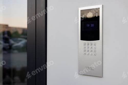 Preview: Doorbell with video camera and microphone, on the white wall of an apartment building, doorbell