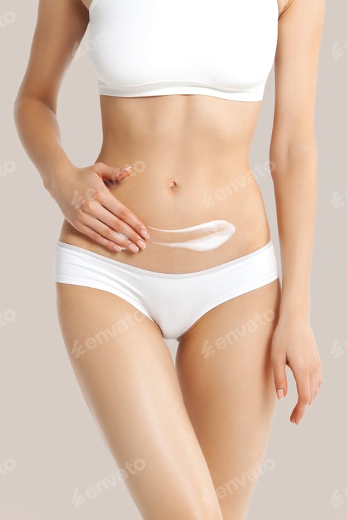 Preview: White slim girl in white lingerie applies cream to her lower abdomen