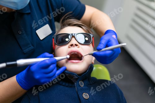 Preview: Woman dentist make preventive dental plaque cleaning for teenager