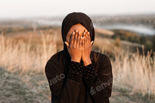 Preview: African muslim woman performing Solat outdoors. Ramadan prayer ritual