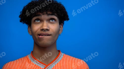 Preview: Thoughtful african american man looking up isolated on blue