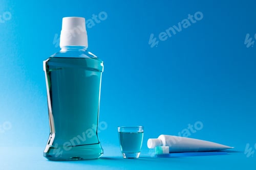 Preview: Image of cleaning liquid, toothbrush and toothpaste on blue surface