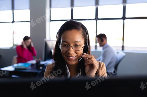 Preview: African American woman working with headset phone in office