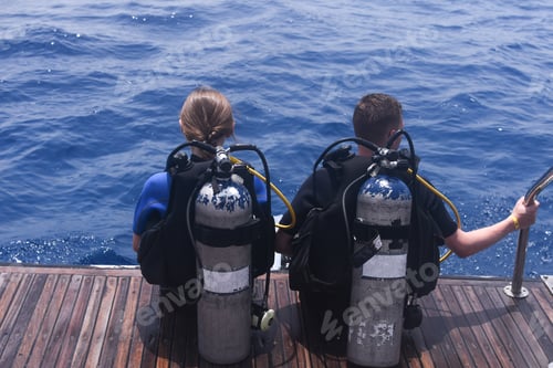 Preview: a man and a woman with scuba gear in diving suits are preparing to dive into the water.