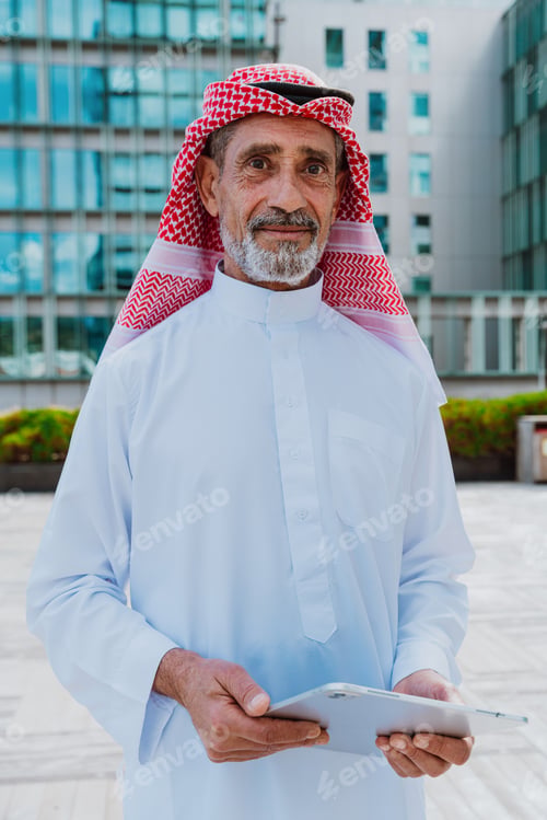 Preview: Senior arab man wearing traditional middle eastern ghutra and thobe