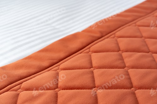 Preview: White Bed With Orange Pillow And Quilted Blanket In Modern Bedroom