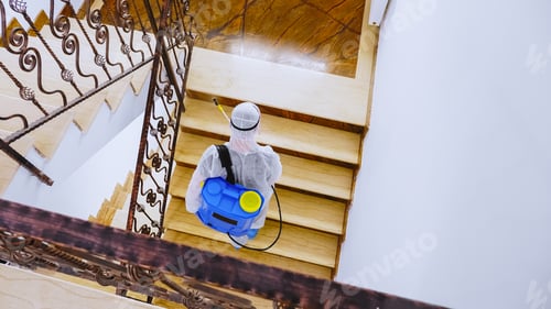 Preview: Worker in hazmat suit spreading disinfectant