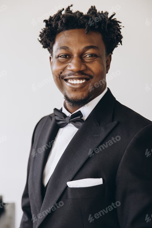 Preview: Elegant businessman wearing suit and bow tie smiling confidently