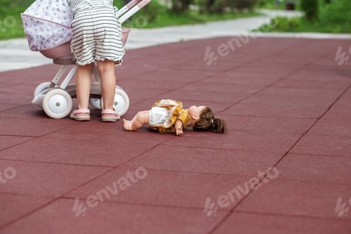 Preview: Toddler girl playing with toy stroller with doll. Developmental milestones. Copy space