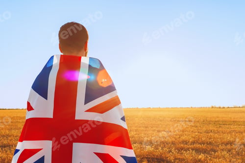 Preview: Man with a flag of Great Britain standing in field