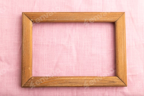 Preview: Wooden frame on smooth pink linen tissue. Top view, natural textile background.