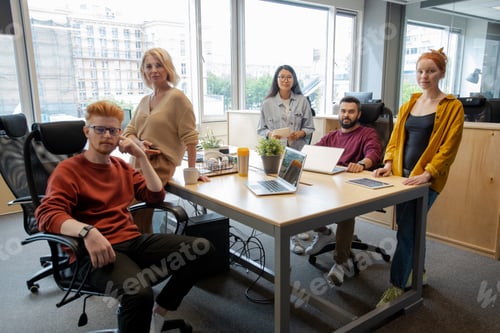 Preview: Group of intercultural business people gathered by table for start-up meeting
