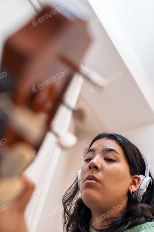 Preview: Singer songwriter composing music with acoustic guitar and headphones at home
