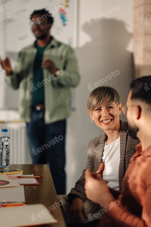 Preview: Businesswoman smiling during a meeting with colleagues