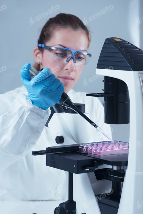 Preview: Female scientist with microscope and micro pipette working in la