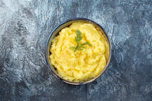 Preview: Close up view of mashed potatoes served with dill on dark color background with free space