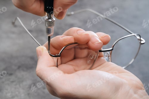 Preview: Closeup of optician master making new eyeglasses in optics using special professional tools