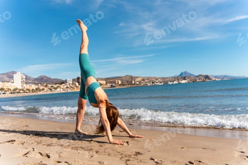 Preview: Woman practicing yoga pose on the beach in spain