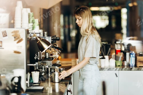 Preview: A young pretty thin blonde with long hair,dressed in casual outfit,is cooking coffee in a modern