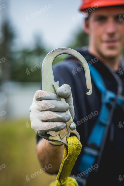 Preview: Technician man in hardhat showing safety hook.