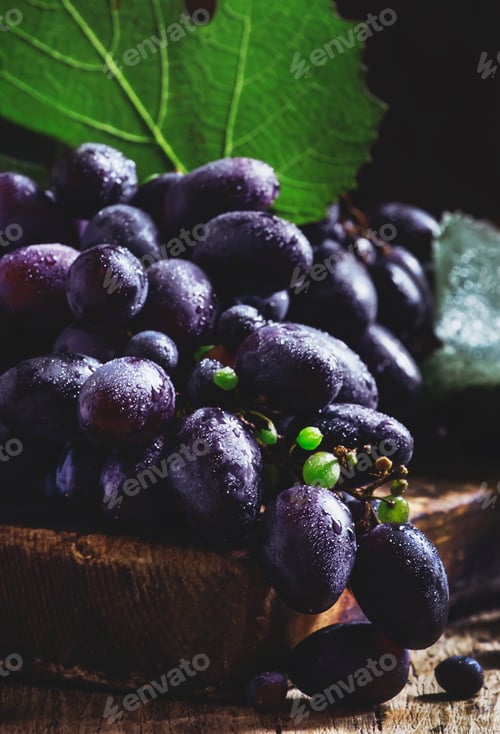 Preview: Blue grapes with vine and green leaves, rustic still life