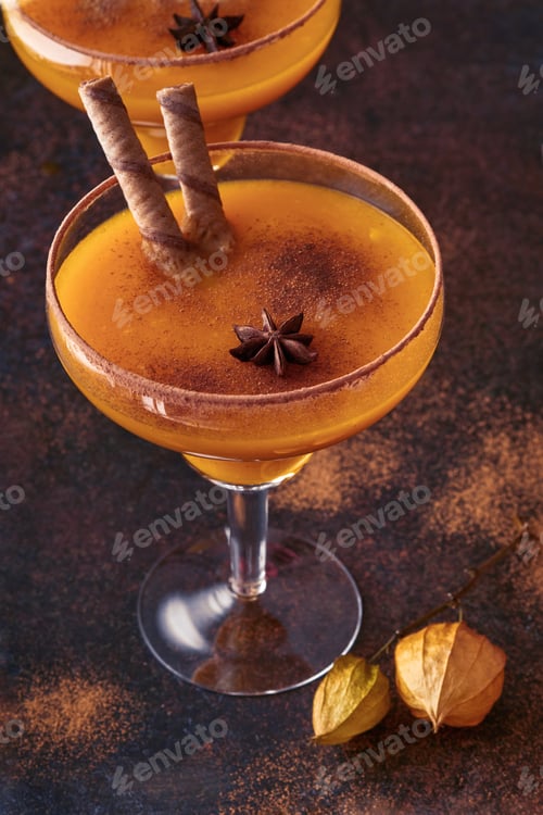 Preview: Pumpkin cocktail with cinnamon, orange juice and cocoa in glass mugs. Pumpkin autumn drink for Hallo