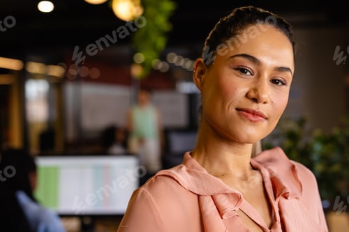 Preview: Portrait of happy biracial casual businesswoman in office