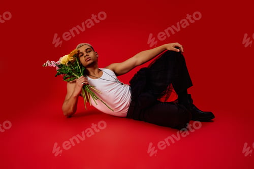 Preview: Young African American man showcases trendy fashion in vibrant red studio