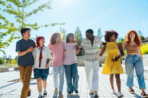 Preview: Multiethnic group of young friends meeting and having fun outdoors
