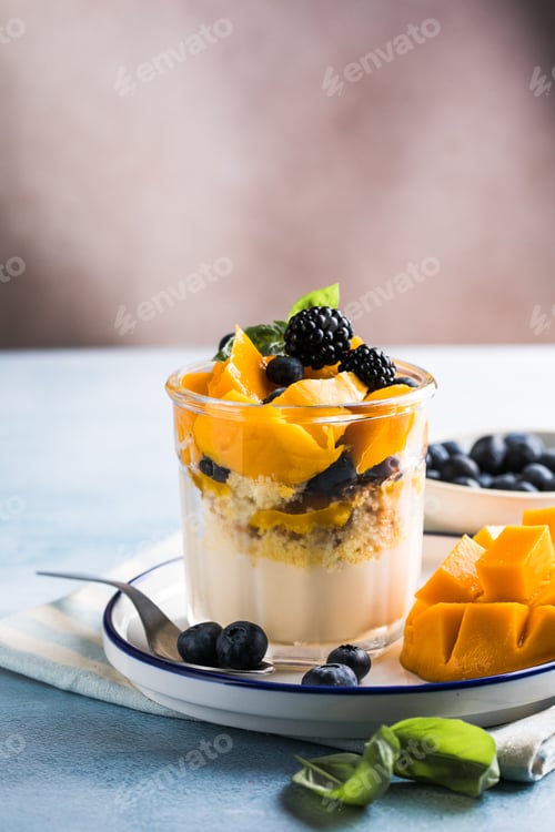 Preview: Trifle dessert with berries and cream on wooden table. Copy space